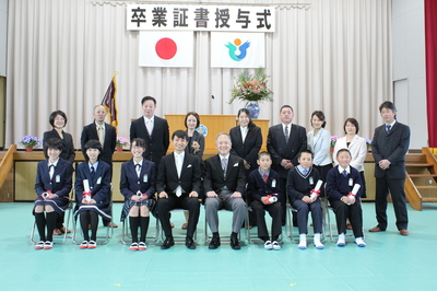 6名の卒業生とともに家族、担任、校長が式場で記念撮影をしました。